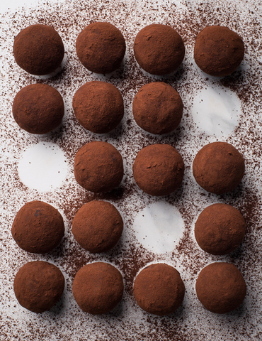 aerial view of vegan chocolate truffles with raw cacao sprinkled around