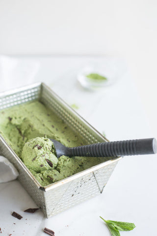matcha chocolate chip ice cream in metal bowl with spoon