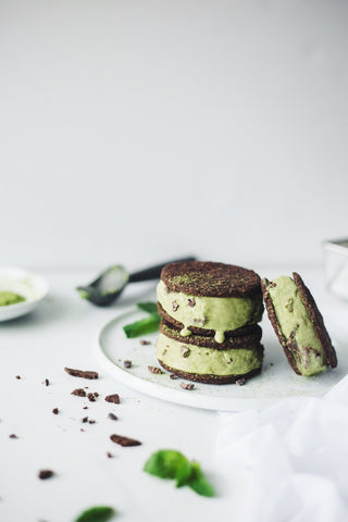 matcha chocolate chip ice cream sandwiches on white plate with chocolate sprinkled