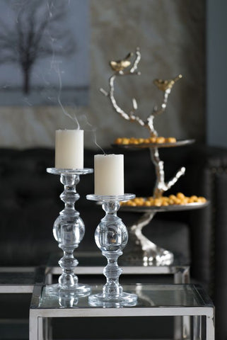 transparent artistic candle holders displayed next to a three tier cake tray with silver branch