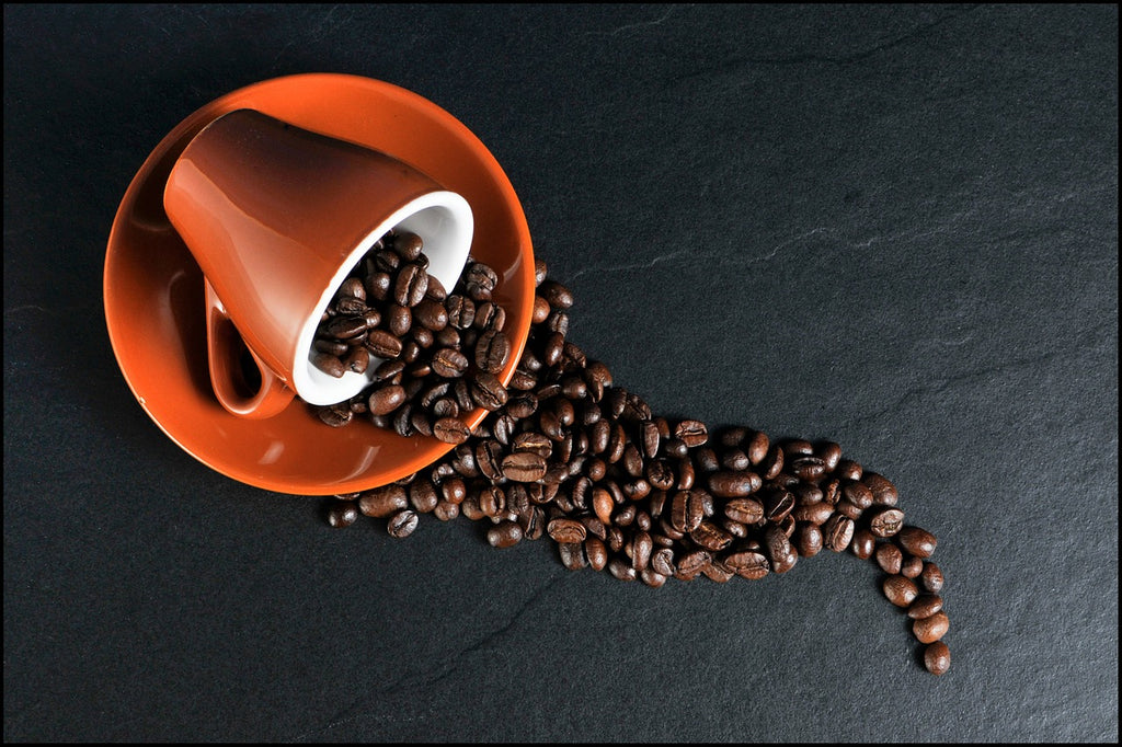 Coffee beans spilling out of a coffee cup