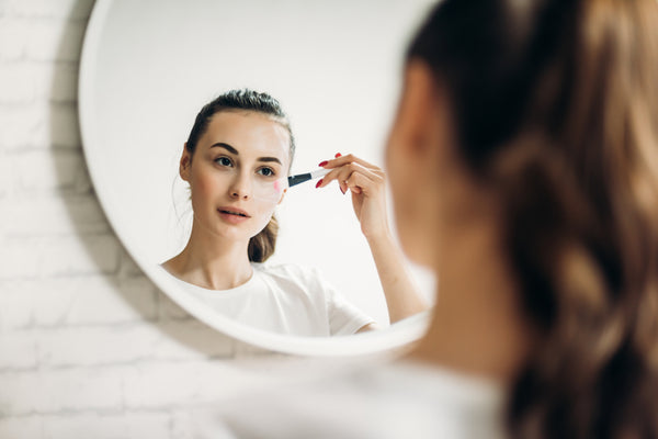 woman apply makeup after using facial oils