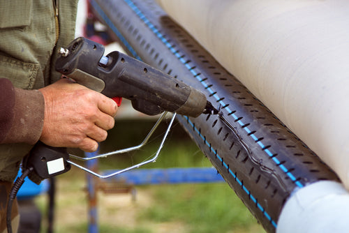 worker fixing perforated pipe