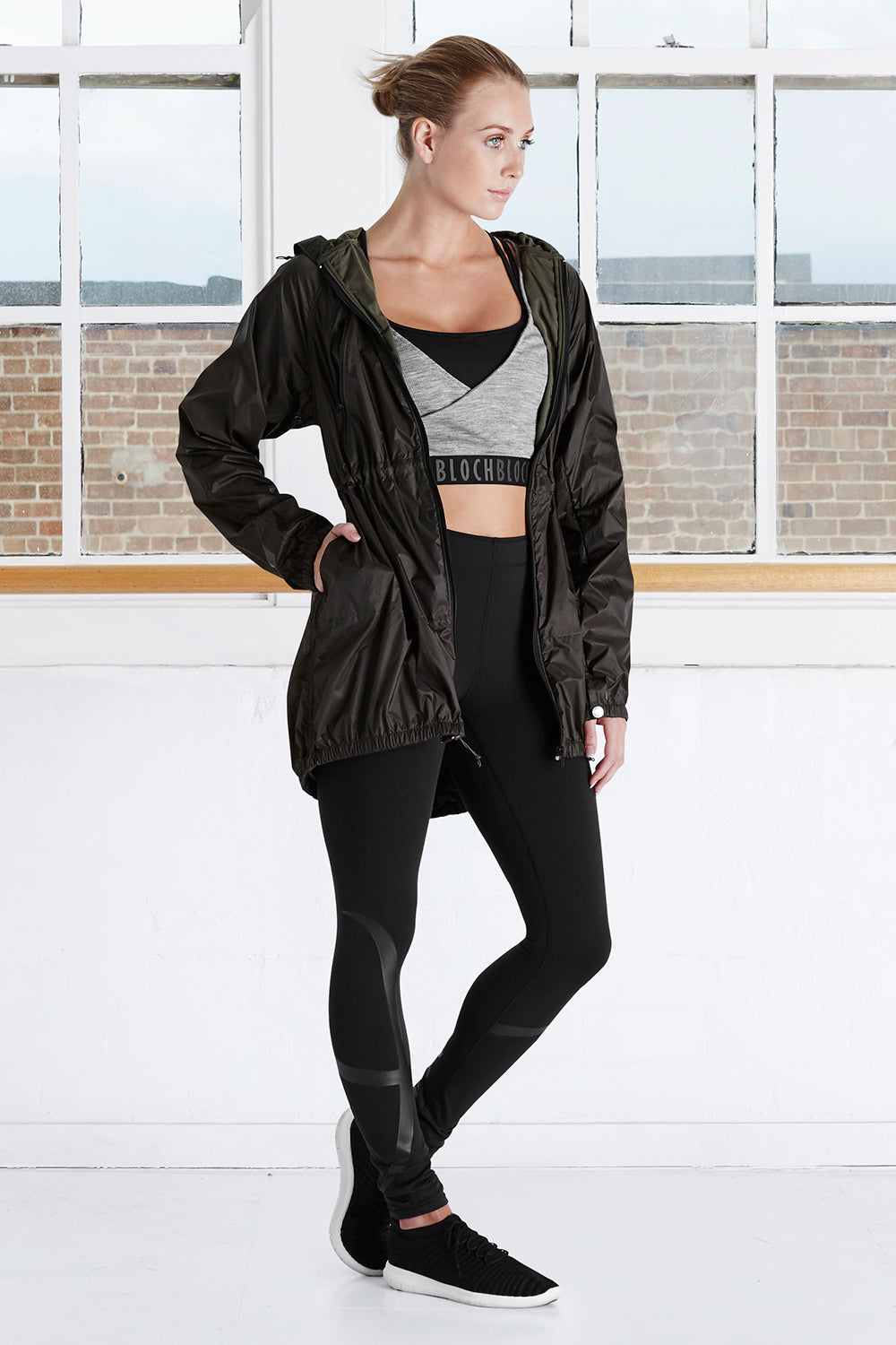 A female dancer in the studio wearing BLOCH workout wear and hooded jacket