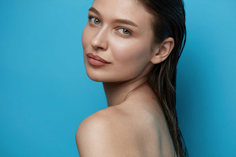 woman with slicked back hair on blue background