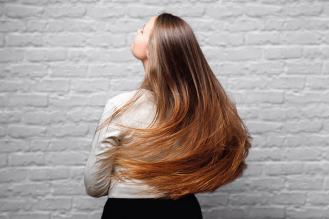 a shot of a woman from behind shaking her beautiful red hair