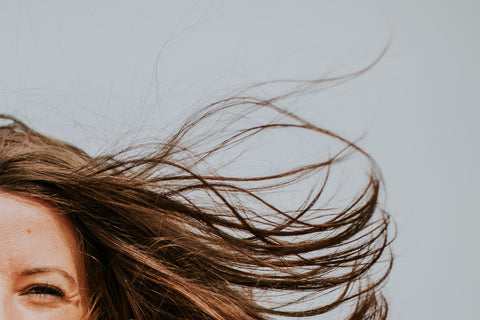 hair flowing in front of a grey background