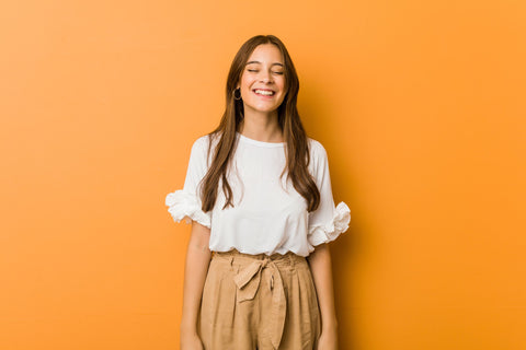 woman smiling on an orange background