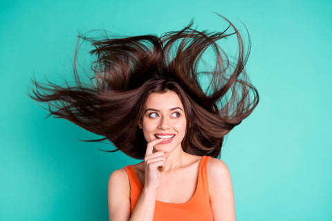 woman a turquoise background with flowing, voluminous hair