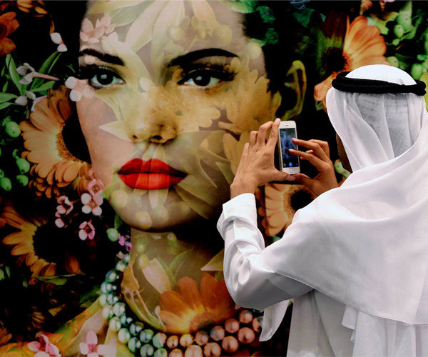 A visitor takes a picture on his iphone at Art Dubai 2014