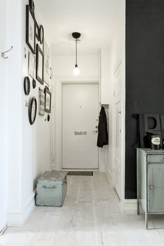 Small apartments can make use of pendant lights, like this narrow, monochromatic interior.