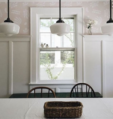 Schoolhouse lighting over dining table in the kitchen. The milky texture of schoolhouse lighting complements all-white rooms perfectly. It gives off that delicate, pastoral feell.