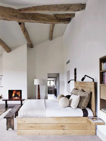 The exposed wooden beams in this wonderfully white bedroom add a modern rustic touch to the decor.
