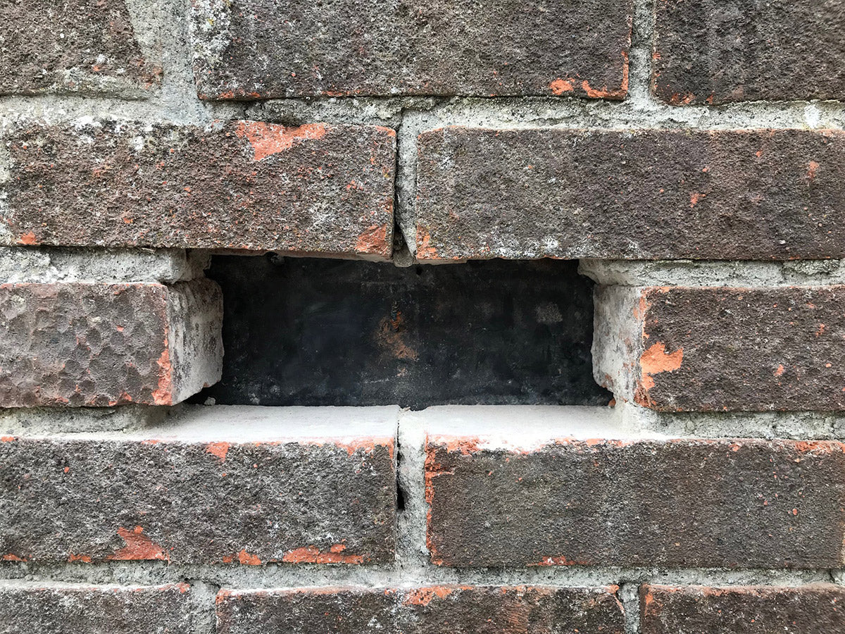 brick drilled out of a brick wall 