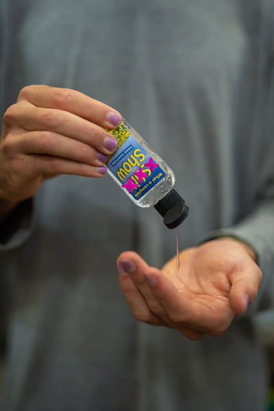 A man holding a funny bottle of hand sanitizer