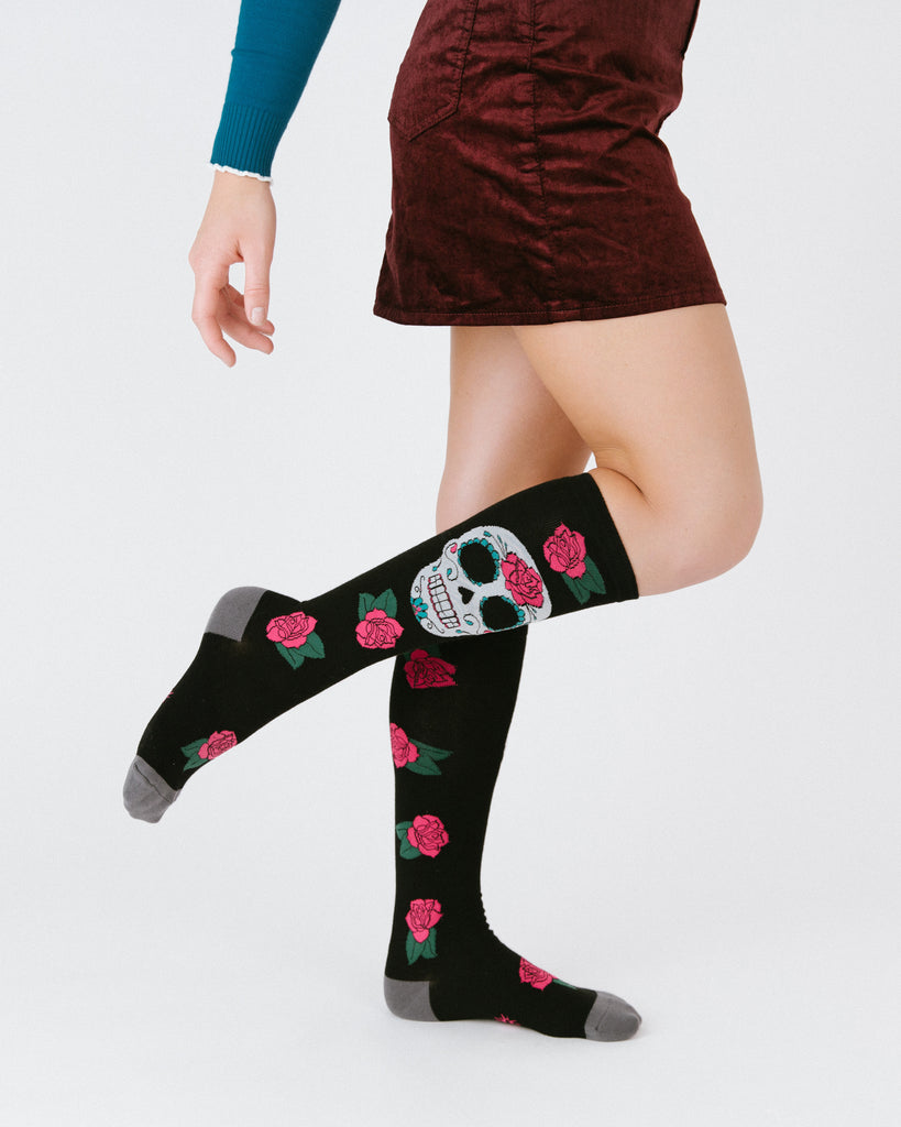 Woman wearing a skirt and cool sugar skull knee high socks