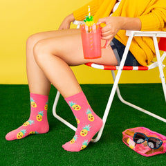 A woman wearing hot pink pineapple socks