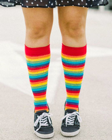 A woman wearing rainbow striped knee high socks
