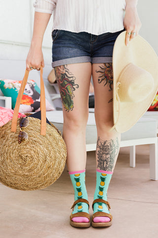 A woman wearing fun pineapple socks