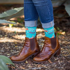 A woman wearing funny flamingo socks that say, "I don't give a flock"