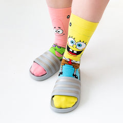 A woman wearing SpongeBob socks and slide sandals