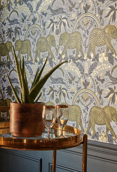 The Zambezi metallic Gold Wallpaper featuring elephants inspired by an African Safari, full of Animal Magic. Designed by Emma J Shipley in collaboration with Clarke & Clarke