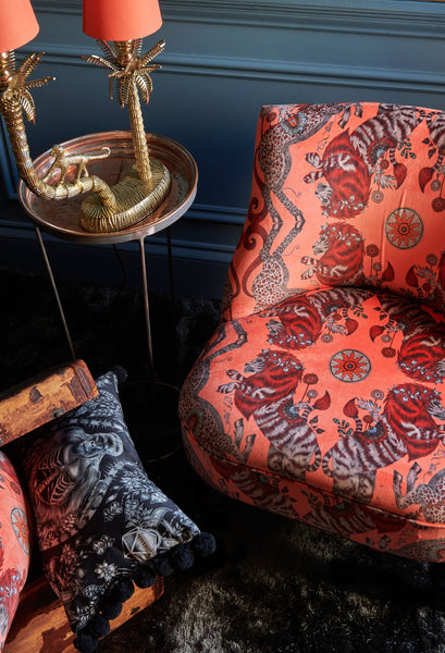 The Caspian Coral Velvet used to upholster a bedroom chair, the exciting design is inspired by the Chronicles of Narnia featuring an iconic British lion and unicorn. Along with a cushion covered in the monochrome Silverback Cotton Satin Fabric that creates a truly unique statement in your interior