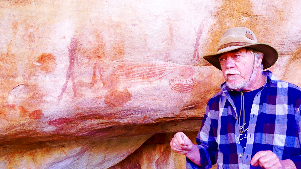 Professor John Parkington, in his element, explaining some unusual motifs in the paintings on the cave behind him