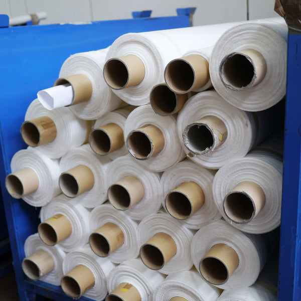 Left: Rolls of pristine fabric, ready for printing. Right: The blank fabrics are checked carefully before being approved for printing. 