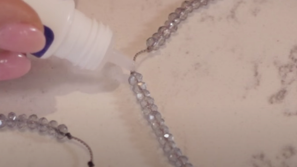 glueing each knot for each tassel segment of beads
