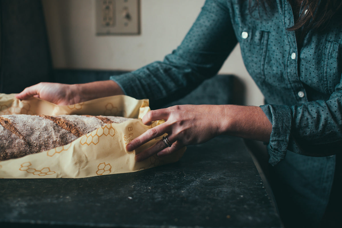 woman wrapping homemade bread in bee's wrap sustainable food storage
