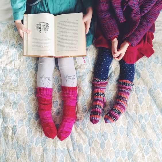طفلتان تقرآن كتابًا وترتديان جوارب جميلة