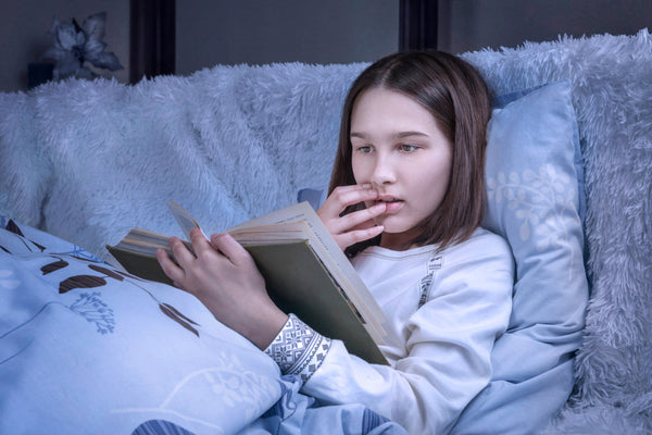 فتاة تقرأ على السرير