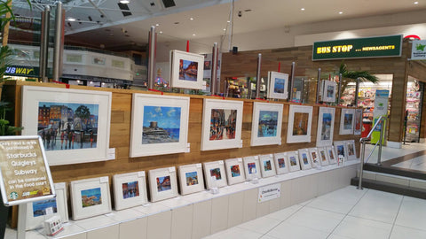 Framed limited edition prints by artist Chris McMorrow for sale on display at the Nutgrove Arts Festival