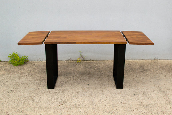 Vista mesa de comedor extensible de diseño industrial con madera maciza de iroko.