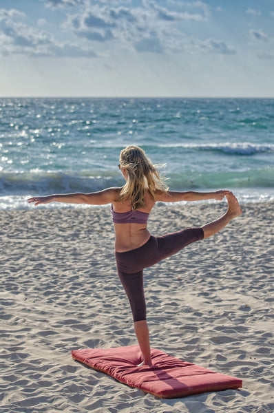 woman doing yoga at the beach