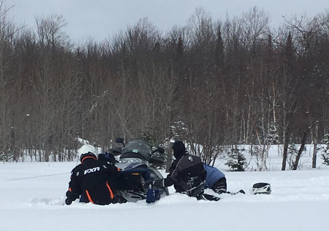 Digging out a snowmobile stuck in snow