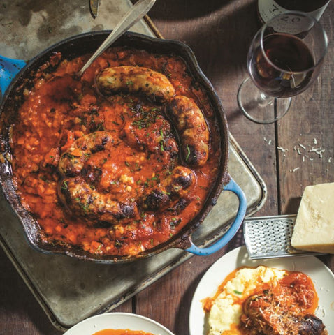 Olympia Provisions Italian sausage in Nonna sauce with a glass of red wine