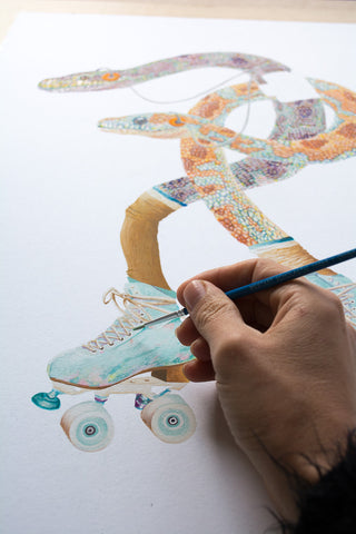 Artist painting snakes wearing Moxi roller skates for Good Art