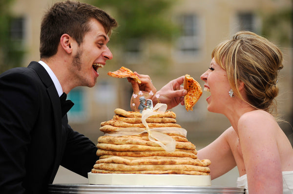Bride and Groom Sharing a Pizza Wedding Cake