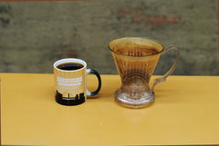 Brewer sitting next to coffee mug full of coffee