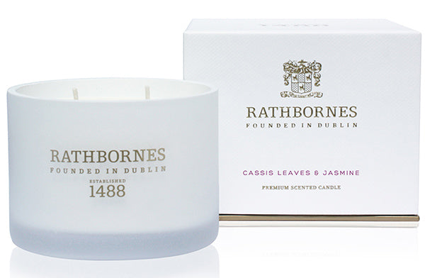 Luxurious scented candle in white jar with notes of jasmine and cassis leaves