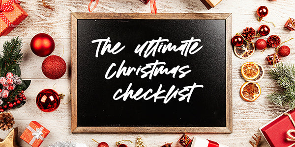 A black board with white text overlay saying The Ultimate Christmas Checklist and X Mas decorations
