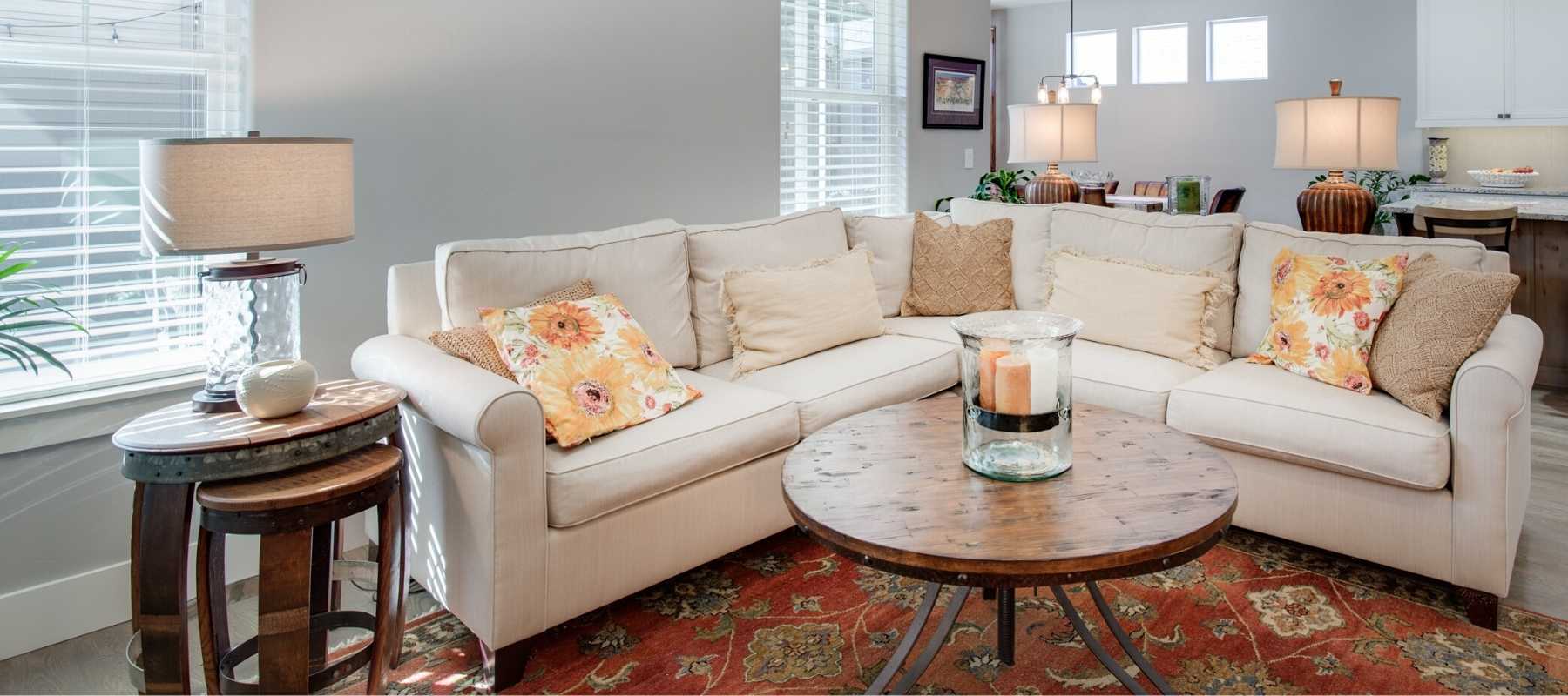 Living room with cream corner sofa and three table lamps