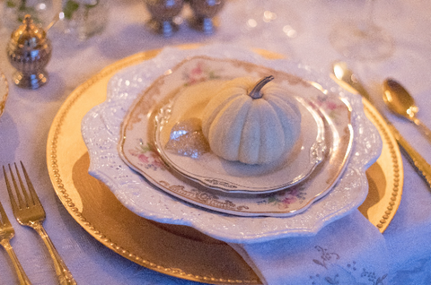A glittery pumpkin on top of Christmas dinner plates