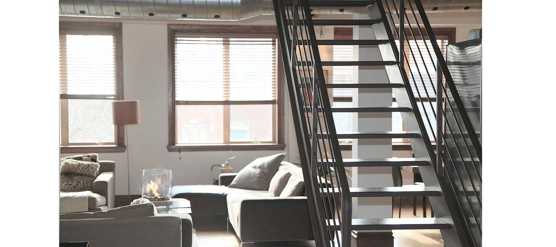 Loft style apartment with metal stairs and large windows