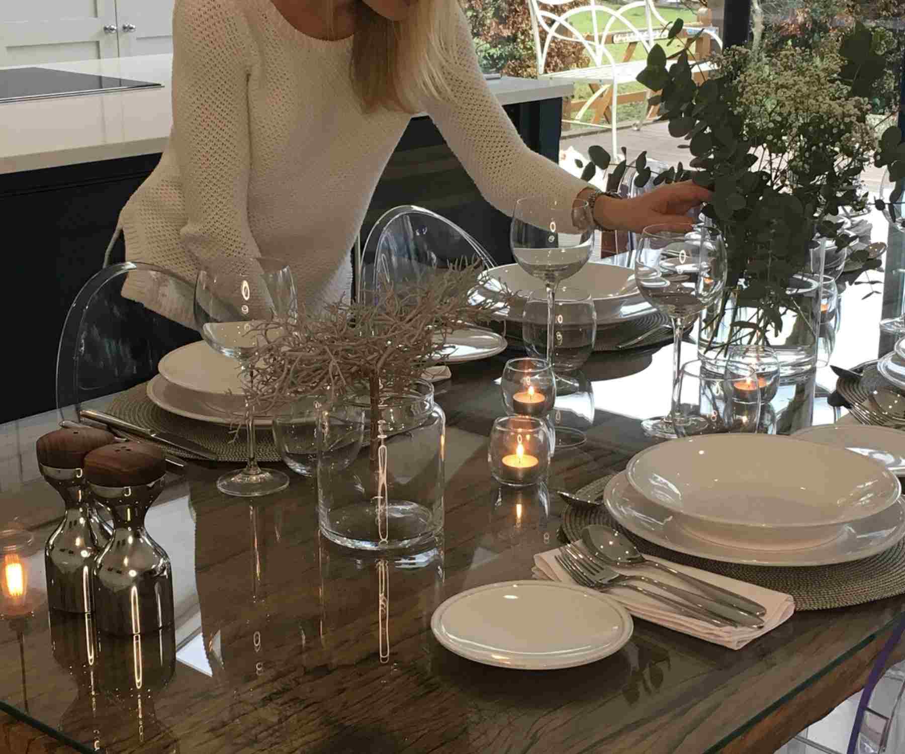 Lady in white jumper laying reclaimed wood dining table