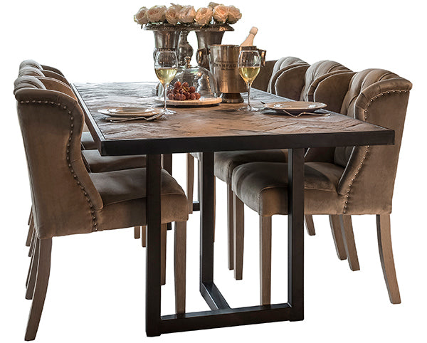 A reclaimed oak extending dining table with black steel legs and velvet dining chairs