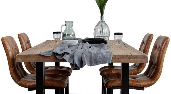 Ashy blue table linen on top of a rustic dining table with industrial dining chairs