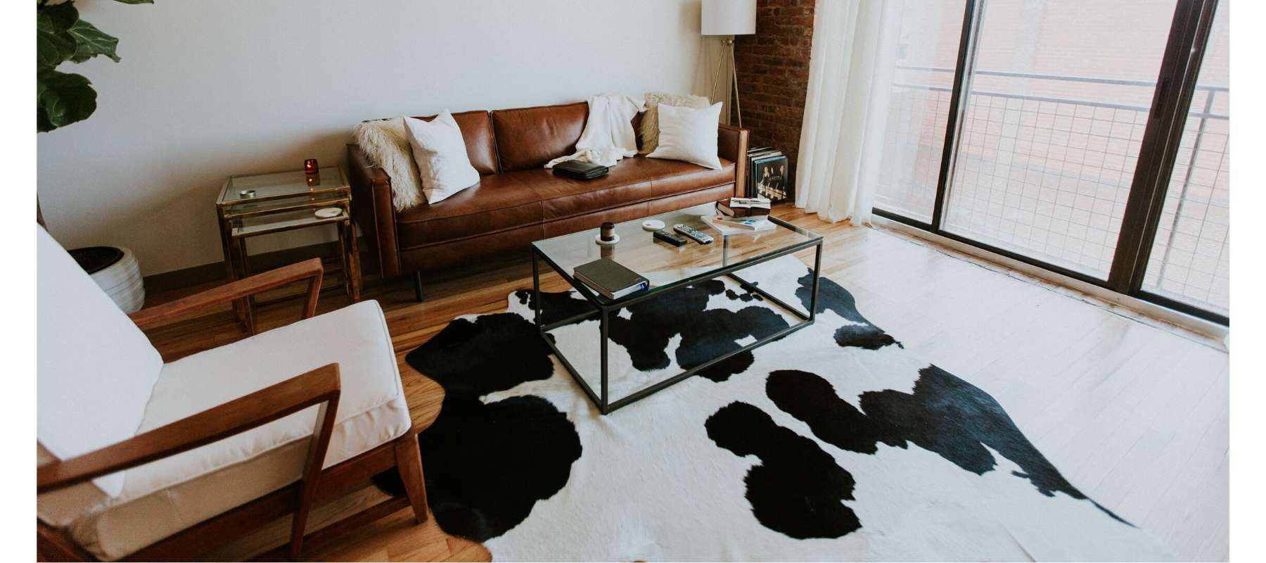 Brown leather sofa with cowhide floor rug